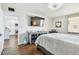 Bright bedroom featuring a large TV, a stylish cabinet, and wood-look flooring at 9425 Blind Pass Rd # 802, St Pete Beach, FL 33706