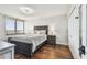 Cozy bedroom with hardwood floors, a comfortable queen bed, a stylish nightstand, and a private balcony with city views at 9425 Blind Pass Rd # 802, St Pete Beach, FL 33706
