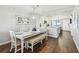 Dining room with dark hardwood flooring, white table and benches with modern chandelier at 9425 Blind Pass Rd # 802, St Pete Beach, FL 33706