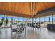 Dining room with water view featuring floor to ceiling windows, high ceilings, and modern decor at 9425 Blind Pass Rd # 802, St Pete Beach, FL 33706