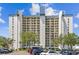 Modern condo building with multi-story balconies and parking in front of lush landscaping at 9425 Blind Pass Rd # 802, St Pete Beach, FL 33706
