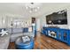 Open-concept living room boasts hardwood floors, contemporary lighting, and stylish blue accents and flows into the kitchen at 9425 Blind Pass Rd # 802, St Pete Beach, FL 33706
