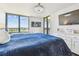Inviting main bedroom with water view, hardwood floors, a large window, bright natural light, and ensuite bathroom at 9425 Blind Pass Rd # 802, St Pete Beach, FL 33706