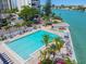 Inviting pool area with lounge chairs, palm trees, and waterfront views at 9425 Blind Pass Rd # 802, St Pete Beach, FL 33706