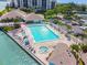 Scenic pool area with lounge chairs, palm trees, hot tub, and waterfront views at 9425 Blind Pass Rd # 802, St Pete Beach, FL 33706
