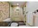 Close-up of the glass shower featuring a stone wall, a rainfall showerhead, and a built-in niche for toiletries at 9425 Blind Pass Rd # 802, St Pete Beach, FL 33706