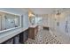 Modern bathroom featuring patterned tile floor, glass shower, and vanity with round mirror at 945 Bunker View Dr, Apollo Beach, FL 33572
