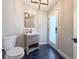 A half bathroom with dark hexagon floors and a decorative sink, illuminated by modern black fixtures at 945 Bunker View Dr, Apollo Beach, FL 33572