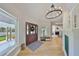 Open-concept foyer with wood-look floors, view of the living area, and a modern chandelier at 945 Bunker View Dr, Apollo Beach, FL 33572