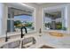 Kitchen sink featuring a pool view and a modern black faucet, complemented by sleek white counters and tile backsplash at 945 Bunker View Dr, Apollo Beach, FL 33572