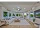 Spacious living room with large windows, a skylight, ceiling fan, and a comfortable white sectional sofa at 945 Bunker View Dr, Apollo Beach, FL 33572