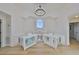 Bright loft space with natural light, hardwood floors, and matching desks, illuminated by a modern chandelier at 945 Bunker View Dr, Apollo Beach, FL 33572