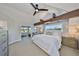 Bright main bedroom with a vaulted ceiling, fan, and expansive windows offering stunning views of the surrounding landscape at 945 Bunker View Dr, Apollo Beach, FL 33572
