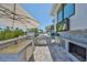 Outdoor kitchen with grill, counter space, and a mounted TV, ideal for outdoor cooking and entertaining guests at 945 Bunker View Dr, Apollo Beach, FL 33572