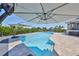 Inviting pool area with umbrellas and clear blue water on a sunny day, perfect for outdoor relaxation and entertaining at 945 Bunker View Dr, Apollo Beach, FL 33572