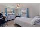 A well-lit bedroom featuring neutral walls, wood-look floors, and dual windows with blue curtains at 9511 45Th N St # 9511, Pinellas Park, FL 33782