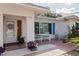 Close-up of the front entrance with vibrant flower accents, outdoor seating and red tile at 9511 45Th N St # 9511, Pinellas Park, FL 33782