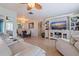 Open-concept living room featuring hardwood floors, white furnishings, and an entertainment center at 9511 45Th N St # 9511, Pinellas Park, FL 33782