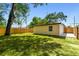 A new, wood fence encloses a level backyard with mature trees at 10011 N Annette Ave, Tampa, FL 33612