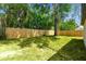 A new, wood fence encloses a level backyard with mature trees at 10011 N Annette Ave, Tampa, FL 33612
