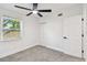A cozy bedroom offers a ceiling fan, neutral carpet, and an abundance of natural light at 10011 N Annette Ave, Tampa, FL 33612