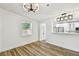 Bright dining room with stylish lighting, wood-look floors, and a view of the kitchen at 10011 N Annette Ave, Tampa, FL 33612
