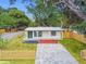 Charming home with a long driveway, fresh exterior, and manicured landscaping at 10011 N Annette Ave, Tampa, FL 33612