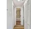 Hallway leading to bathroom featuring white wood doors and contrasting wood and gray carpet flooring at 10011 N Annette Ave, Tampa, FL 33612