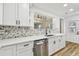 Renovated kitchen with stainless steel dishwasher and mosaic tile backsplash at 10011 N Annette Ave, Tampa, FL 33612