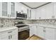 Modern kitchen features white cabinets, quartz countertops, and stainless steel appliances at 10011 N Annette Ave, Tampa, FL 33612