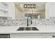 This kitchen offers quartz countertops, a mosaic backsplash, and an elegant faucet at 10011 N Annette Ave, Tampa, FL 33612