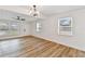Open living room featuring modern lighting, wood-look floors, and multiple windows at 10011 N Annette Ave, Tampa, FL 33612