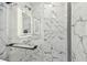 Modern shower with white marble tiles, glass enclosure, and black hardware and fixtures at 10011 N Annette Ave, Tampa, FL 33612