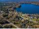 Aerial view shows the house with a lake in the background and lush landscape all around at 10502 Atlee St, New Port Richey, FL 34654