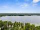 Scenic aerial view of a tranquil lake surrounded by lush green trees under a clear blue sky at 10502 Atlee St, New Port Richey, FL 34654