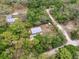 Aerial image displays a property surrounded by dense trees, revealing a peaceful, private lot on winding roads at 10502 Atlee St, New Port Richey, FL 34654