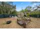 Landscaped backyard featuring a shed, seating area, and a vibrant garden, surrounded by a fence at 10502 Atlee St, New Port Richey, FL 34654