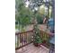 Wooden deck with a potted plant with pink and red flowers overlooking a lush backyard, perfect for outdoor relaxation at 10502 Atlee St, New Port Richey, FL 34654