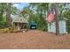Charming property featuring a tiny home, garage, and storage shed, adorned with an American flag amidst lush greenery at 10502 Atlee St, New Port Richey, FL 34654