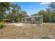 Well-maintained single-story home on landscaped grounds and with outbuildings in the background at 10502 Atlee St, New Port Richey, FL 34654