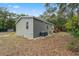 Rear exterior showing the home's siding, a well-manicured lawn, and an AC unit at 10502 Atlee St, New Port Richey, FL 34654
