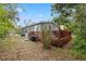 Exterior view of the home featuring a wooden deck with steps, plants and trash cans at 10502 Atlee St, New Port Richey, FL 34654