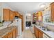 Efficient kitchen with wooden cabinets, appliances, and a view of the adjoining laundry space at 10502 Atlee St, New Port Richey, FL 34654