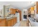 Well-equipped kitchen with wood cabinets, including bar top and modern appliances, adjacent to laundry area at 10502 Atlee St, New Port Richey, FL 34654