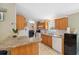 Functional kitchen featuring wooden cabinets, a breakfast bar, and a view of the laundry area at 10502 Atlee St, New Port Richey, FL 34654