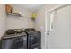 Bright laundry room features a modern washer and dryer and convenient shelving at 10502 Atlee St, New Port Richey, FL 34654