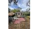 Outdoor shed with a cozy seating area and a small patio, surrounded by greenery at 10502 Atlee St, New Port Richey, FL 34654