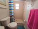 Bathroom features a classic shower with colorful curtain, toilet, towel and matching accessories at 11625 Constance Dr, Port Richey, FL 34668