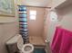 Bathroom features a classic shower with colorful curtain, toilet, towel and matching accessories at 11625 Constance Dr, Port Richey, FL 34668