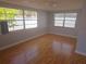 Calm bedroom featuring hardwood floors, neutral walls, and large windows providing natural light at 11625 Constance Dr, Port Richey, FL 34668